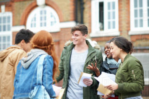 group of students looking happy and chatting outside.