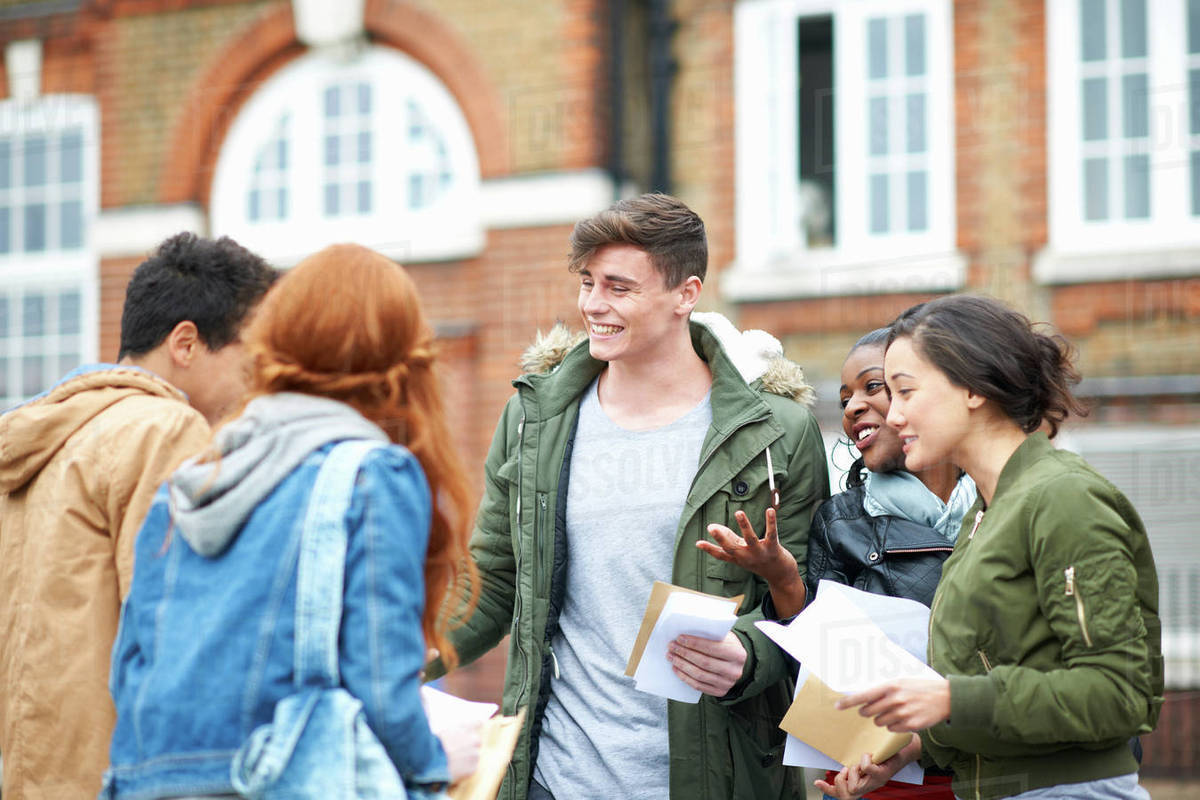 group of students looking happy and chatting outside.