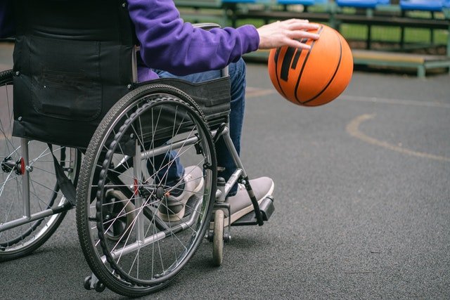 Person in Purple Jacket Holding Orange Basketball