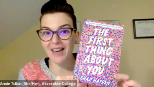 Annie Tulkin: woman with glasses and faux hawk hair. She is making a fun, surprised, smiley face. She is holding a book with lots of colors on the front "The First Thing About You" by Chaz Hayden